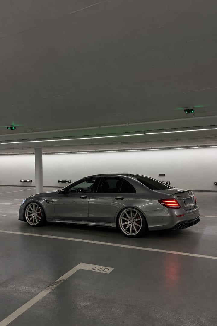Side profile of the lowered Mercedes-AMG E 63 S with glowing tail lights and rear spoiler